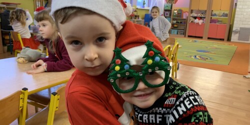 Dwóch chłopców w przebraniach mikołajowych  - czapki i okulary z choinką