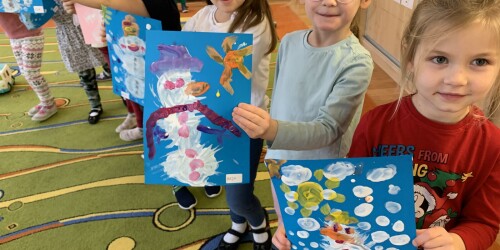 trzy dziewczynki pokazują swoje prace