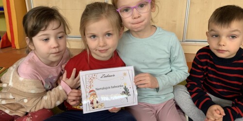 trzy dziewczynki pokazują zadanie zapisane na kartce