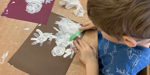 chłopiec maluje szczoteczka do zębów białego bałwanka