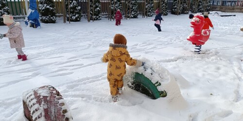 chłopiec zgarnia śnieg z opony