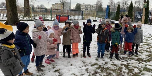 dzieci stoją łukiem na śniegu