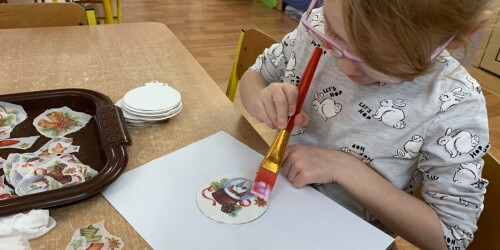 dziewczynka maluje po drewnianej bombce