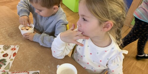 dziewczynka oblizuje palce po wypiciu gorącej czekolady z piankami