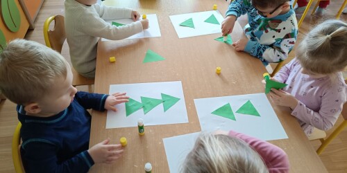 dzieci układają choinkę z figur geometrycznych