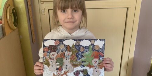 dziewczyna pokazuje swój obrazek zimowego pejzażu