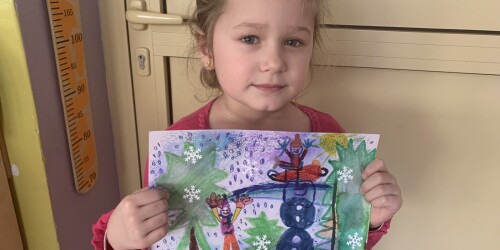 dziewczynka prezentuje swój obrazek- zimowy pejzaż