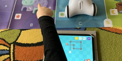 dziecko programujące poruszanie się robota na tablecie
