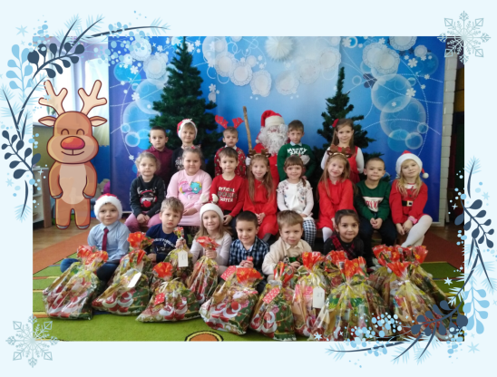grupa dzieci pozuje z Mikołajem i prezentami do zdjęcia