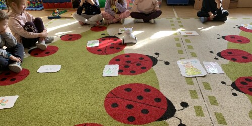 dzieci siedzą na dywanie - jedno z nich steruje robotem 4