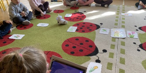 dzieci siedzą na dywanie - jedno z nich steruje robotem 2