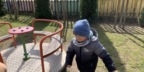 chłopiec biegnie koło karuzeli
