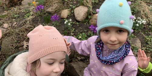 dwie dziewczynki wskazują kwitnące kwiatki