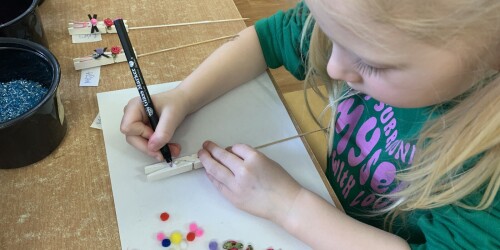 dziewczynka wykonuje zajączka- maluje flamastrem uszy