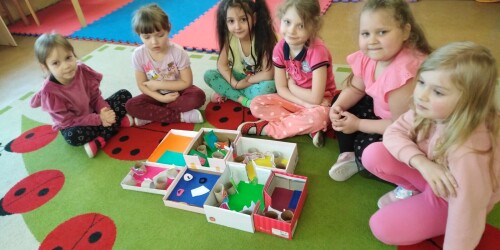 Dziewczynki prezentują grupowo wykonany dom Kubusiowego Przyjaciela Natury