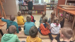 Dzieci słuchają opowieści bibliotekarki