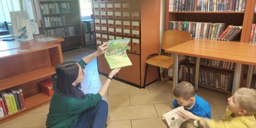 Bibliotekarka pokazuje dzieciom ilustracje